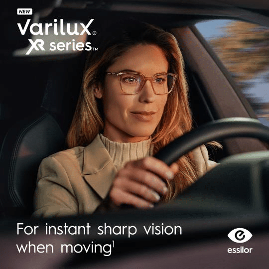A woman wearing glasses drives a car. Text on image: “Varilux XR series—Experience instant sharp vision when moving with an Essilor Lens.” Essilor logo in the corner.